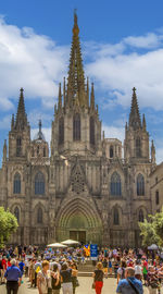 The orchestra of musicians plays music in the square in front of the barcelona cathedral. catalonia