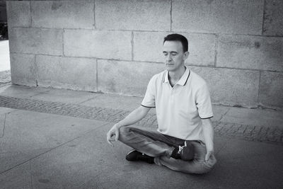 Portrait of young man standing against wall