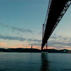 Low angle view of bridge over river against sky at night