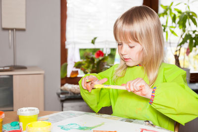 Close-up of boy sitting on table at home