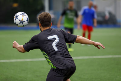 Rear view of soccer player playing field