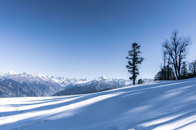 Scenic view of snowcapped mountains against clear blue sky