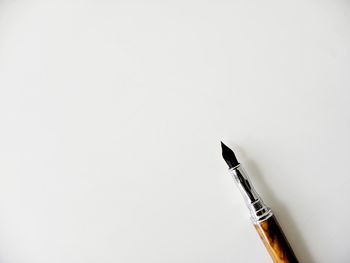 Close-up of pen over white background