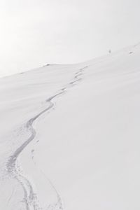 Snow covered land against sky