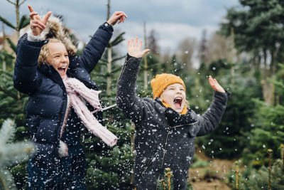 Brother and sister having fun with snow before christmas