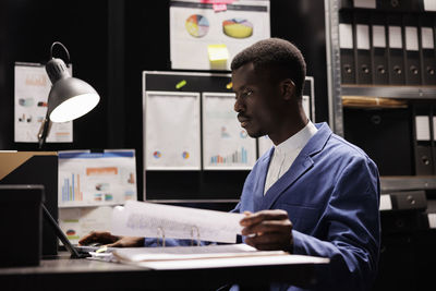 Portrait of businessman using laptop at office