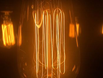 Close-up of illuminated light bulb at night