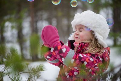 Close-up of girl with soap bubbles in winter