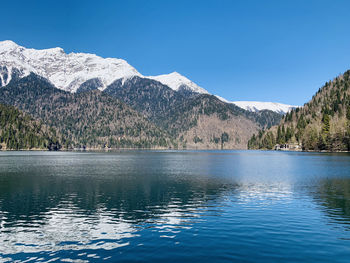 Scenic view of lake and mountains against blue sky