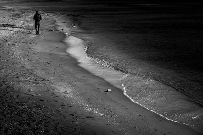 Rear view of woman walking on beach