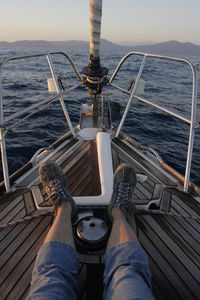 Low section of person on boat in sea against sky