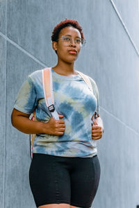 Portrait of woman standing against wall