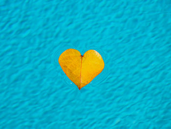 Close-up of heart shape on blue sea