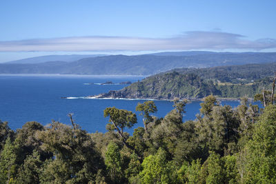 Scenic view of sea and mountains against blue sky