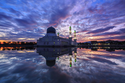 Reflection of building in lake at sunset