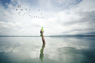 Woman in sea against sky