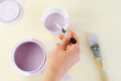 High angle view of hand holding tea cup on table