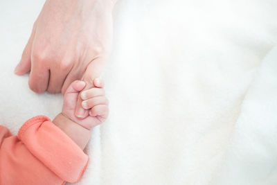 Close-up of baby hand on bed