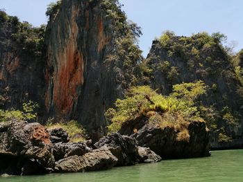 Scenic view of rocks by sea against sky