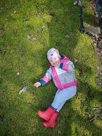 High angle portrait of laughing girl laying on field