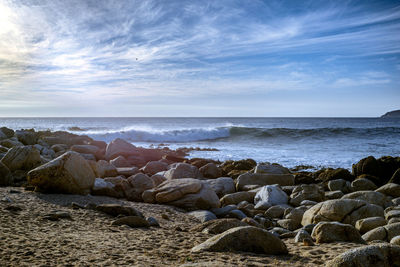 Rocks on beach against sky