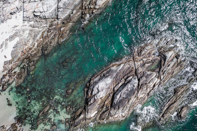High angle view of rocks on sea shore