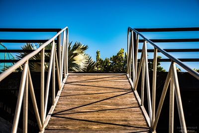Footbridge against clear blue sky