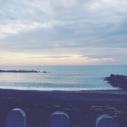 Low section of beach against sky during sunset