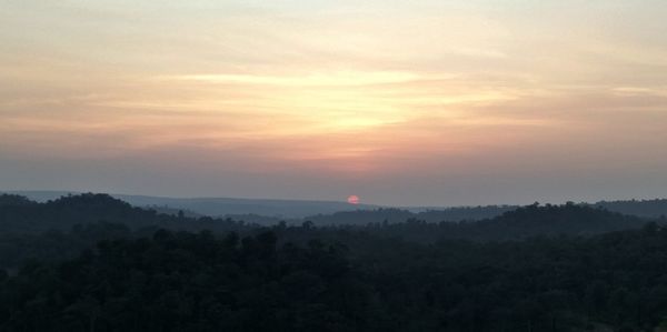 Scenic view of silhouette mountains against sky at sunset