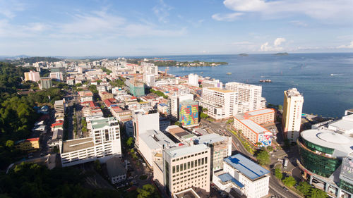 High angle view of buildings by sea against sky