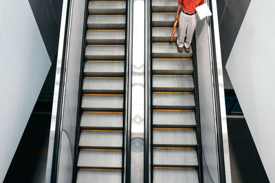 Low section of man standing on escalator