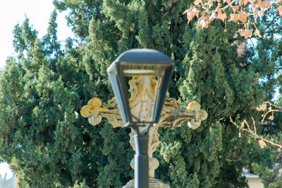 Low angle view of street light against trees