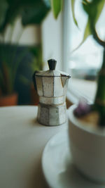 Coffee pot on table by window