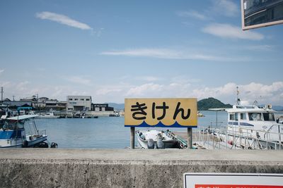 Information sign in city against sky