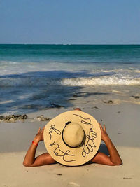 Person on beach by sea against sky