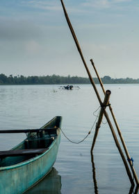 Sailboats moored in lake against sky