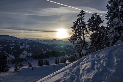 Scenic view of snow covered mountains against sky during sunset