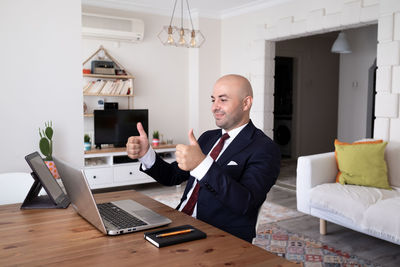 Executive businessman giving okey working at home office.