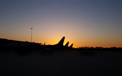 Silhouette airplane against sky during sunset