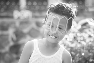 Close-up portrait of smiling boy with toy on face