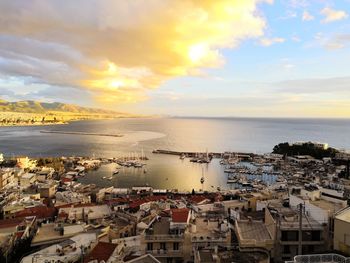 High angle view of townscape by sea against sky