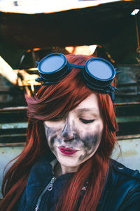 Woman looking down with charcoal stain on face