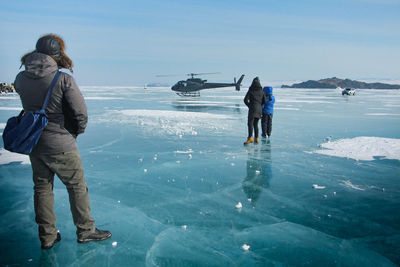 Rear view of man standing in sea