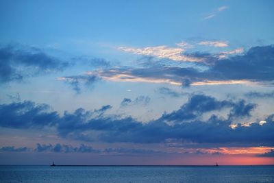 Scenic view of sea against dramatic sky during sunset