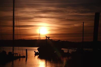 Silhouette sailboats in sea against sky during sunset