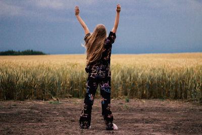 Rear view of woman standing on field