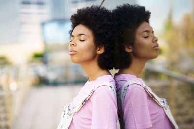 Woman with afro hairstyle standing against wall