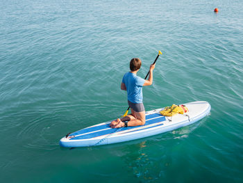 Paddle boarder.sportsman on knees paddling on stand up paddleboard. sup surfing.outdoor recreation. 