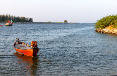 Boat moored in river against sky