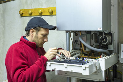 Side view of man working on machine